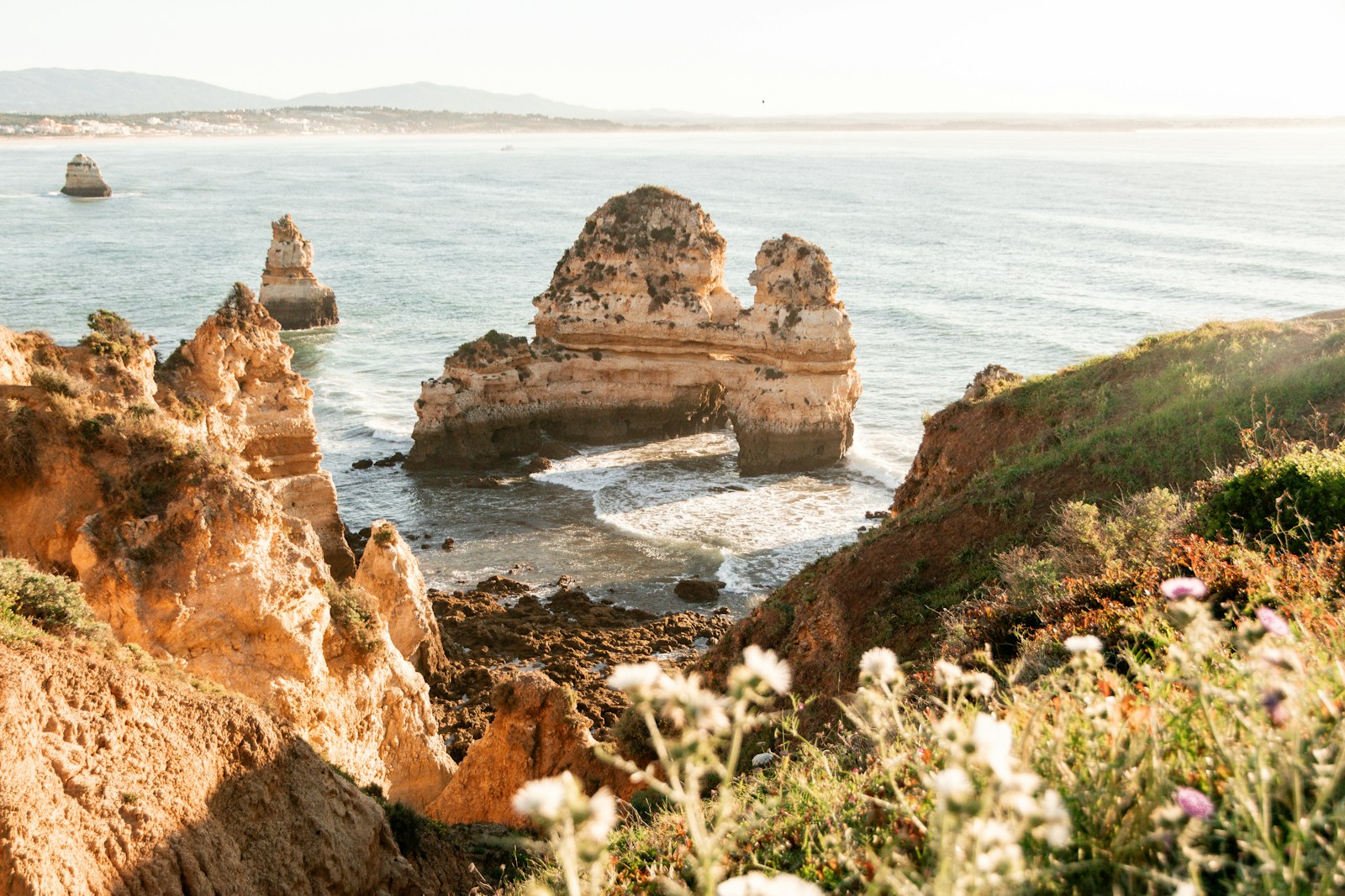 A group of rocks sitting on top of a cliff next to the ocean